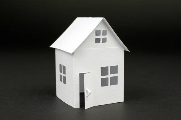 istock white small house on blurred dark background, close up 1033707550