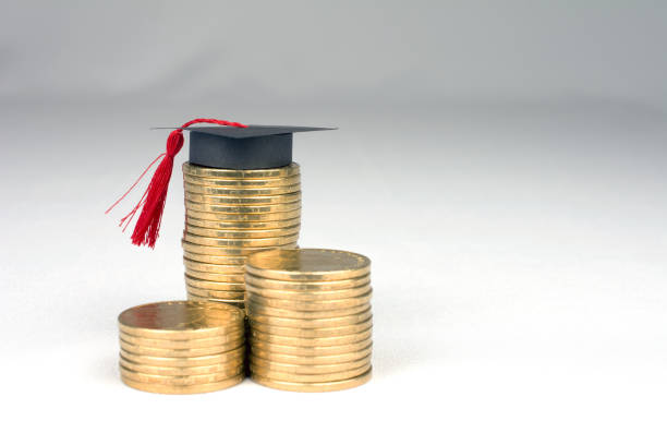 istock graduation mortarboard and golden coins on white background 1033708178