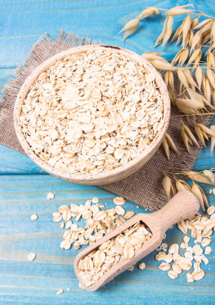 istock Oat flakes in a bowl on the blue board. 1033720198