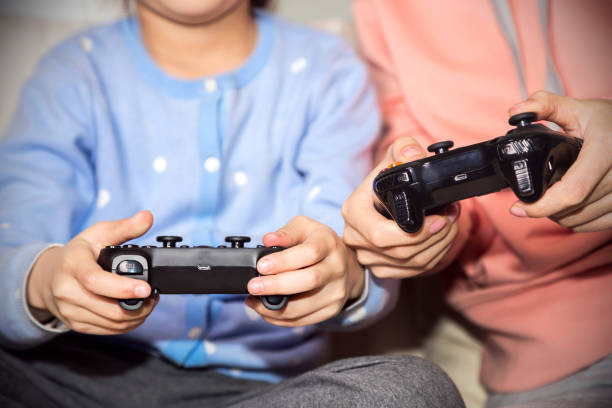 istock Mother and daughter playing  games by joystick 1033723312
