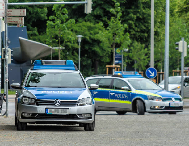 две немецкие полицейские машины с серой и синей разметкой ждут своего использования - german culture flash стоковые фото и изображения