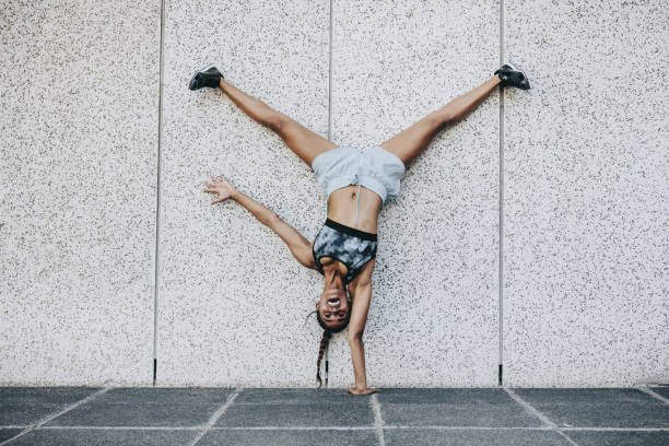 istock Fitness woman standing upside down on one hand 1033735304