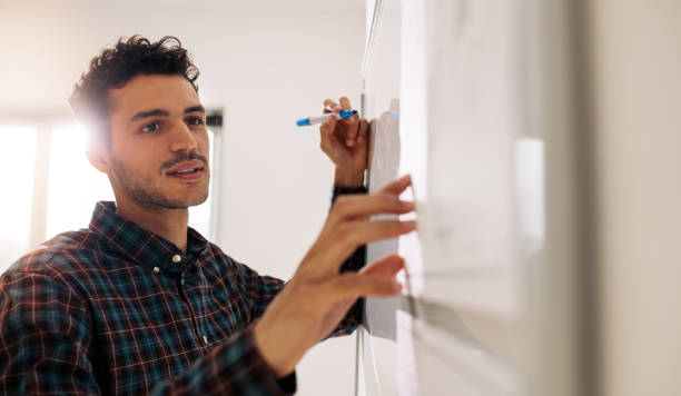 istock Businessman writing on whiteboard in office 1033736276