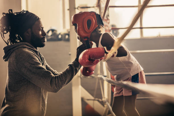 istock Boxing kid standing inside a boxing ring talking to his coach 1033739884