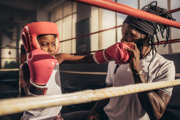 istock Boxing kid training with his coach at a boxing gym 1033739998