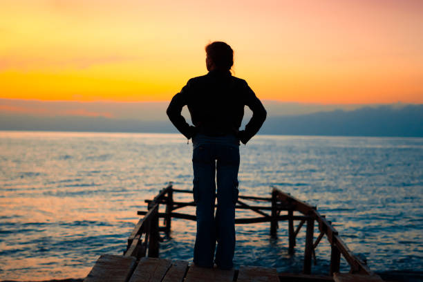istock girl on the dock at sunset 1033750940