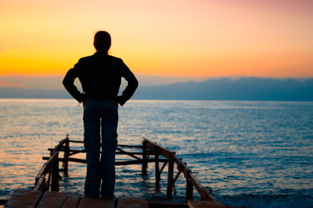 istock girl on the dock at sunset 1033750948