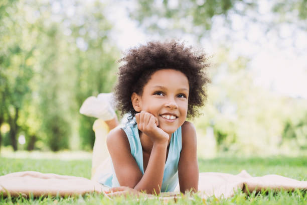 istock Beautiful little kid girl lying on a grass 1033753572