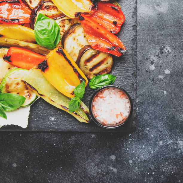 istock Grilled multicolored vegetables, aubergines, zucchini, pepper with green basil on serving stone board 1033766336