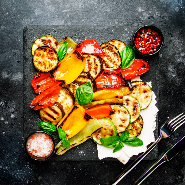 istock Grilled multicolored vegetables, aubergines, zucchini, pepper with green basil on serving stone board 1033767550