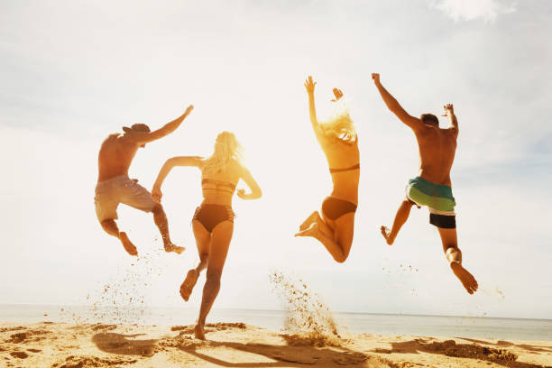 istock Happy friends sunset beach run jump 1033773632