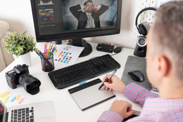 istock Graphic designer uses a pen and graphic tablet 1033773950