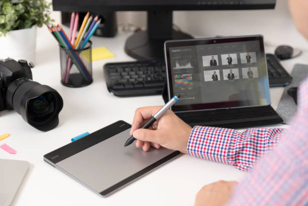 istock Graphic designer uses a pen and graphic tablet 1033773966