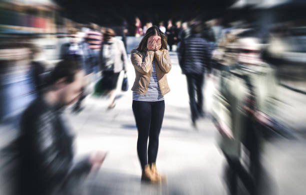 Panic attack in public place. Woman having panic disorder in city. Psychology, solitude, fear or mental health problems concept. Panic attack in public place. Woman having panic disorder in city. Psychology, solitude, fear or mental health problems concept. Depressed sad person surrounded by people walking in busy street. solitude stock pictures, royalty-free photos & images
