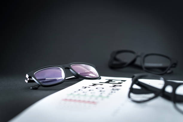 istock Glasses on eye sight test chart with different spectacle options on optician table. Ophthalmology or optometry clinic. 1033774304