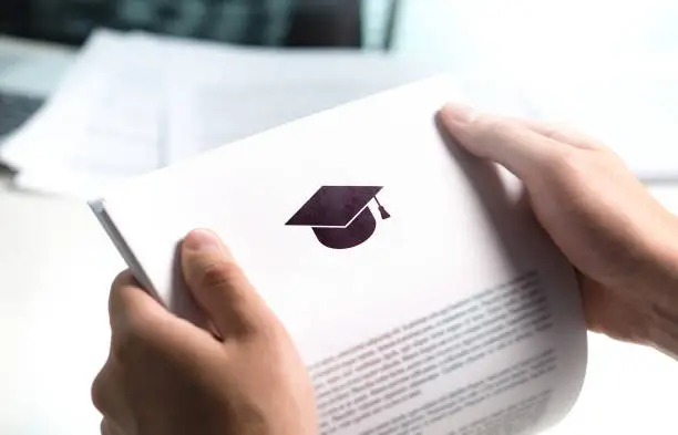 Photo of College or university application or letter from school. Student or teacher reading education document. Young man holding grant, graduation or study loan paper.