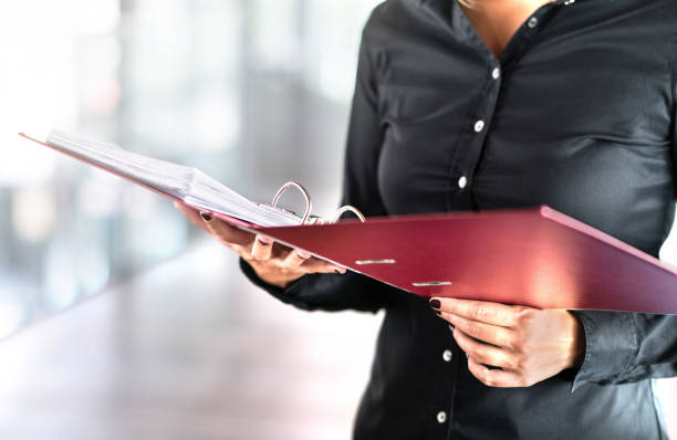 female social worker, detective or business woman reading files in open folder. accountant, investigator or adoption counselor. volunteer in voluntary work. - ring binder fotos imagens e fotografias de stock