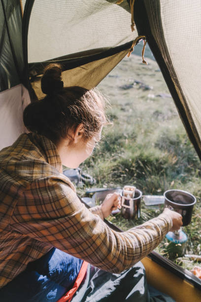 istock Woman cooking in the tent while hiking 1033777260