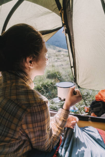 istock Woman drinking from cup  in the tent 1033777470
