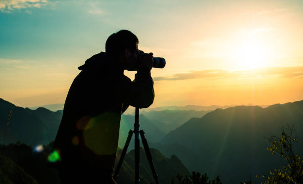istock Photographer taking photo on sunset mountain 1033789776