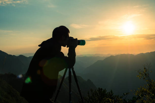 istock Photographer taking photo on sunset mountain 1033789786