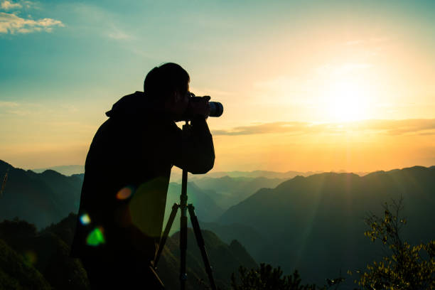 istock Photographer taking photo on sunset mountain 1033789792
