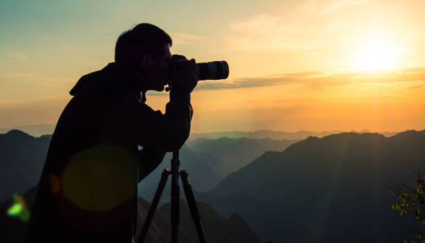 istock Photographer taking photo on sunset mountain 1033789800