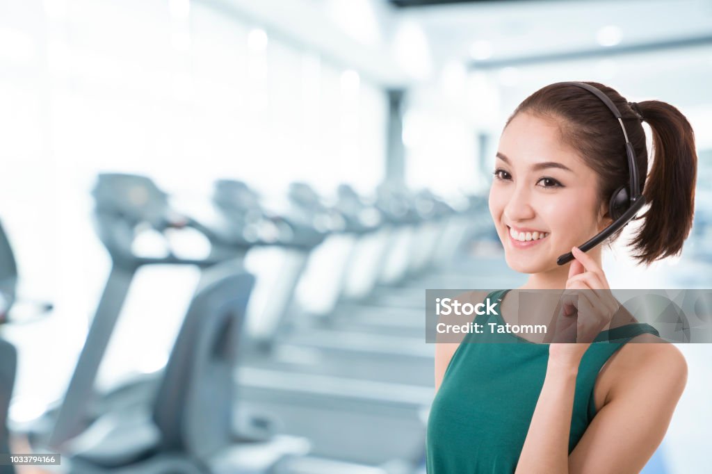 Asian Women Trainer Call Center With Phone Headset With Blur Image Of Gym Background Class Training Concept Stock Photo - Now - iStock