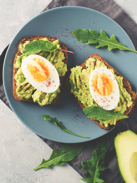 istock Avocado toasts with eggs and salad on breakfast 1033795148