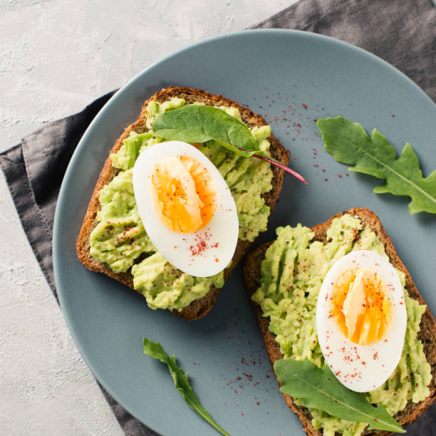 istock Avocado toasts with eggs and salad on breakfast 1033795154