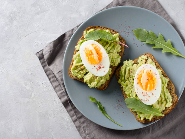 istock Avocado toasts with eggs and salad on breakfast 1033795174