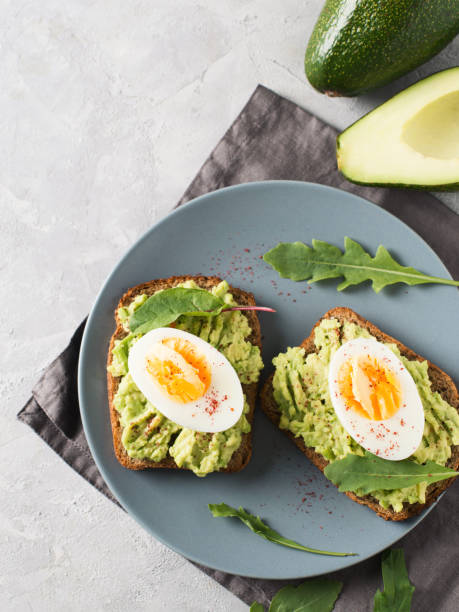istock Avocado toasts with eggs and salad on breakfast 1033795176