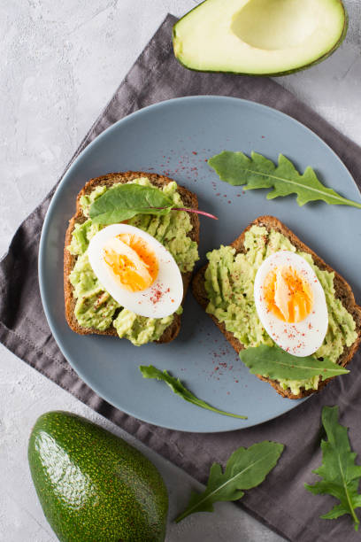 istock Avocado toasts with eggs and salad on breakfast 1033795208