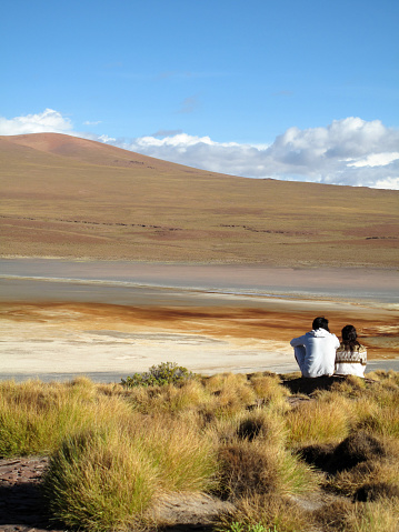 Altiplano, Bolivia - January 11, 2010: Young couple enjoying the dramatic Altiplano landscape. This area has one of the most outstanding views in the world