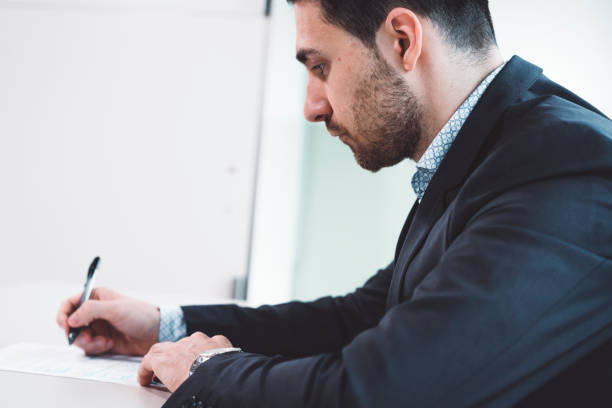 istock Young businessman writing with his pen 1033795636