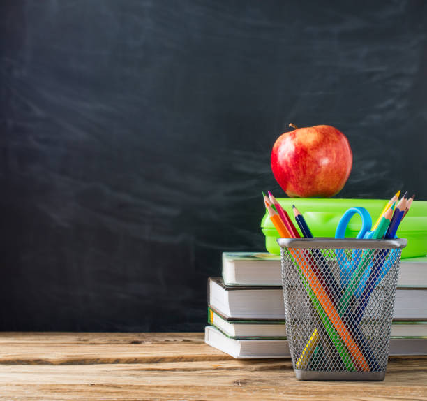 istock School books with stationery and apple on blackboard background 1033796268