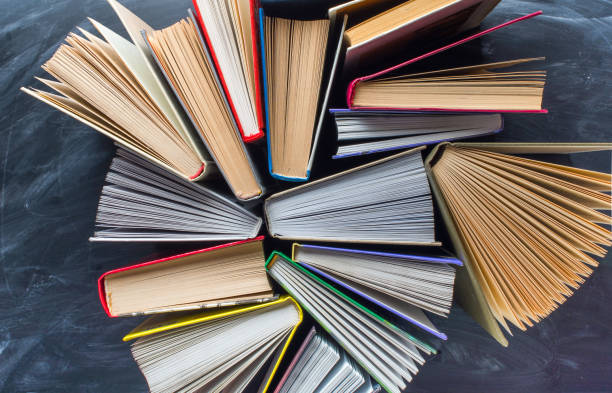 Some books on the desk over the blackboard