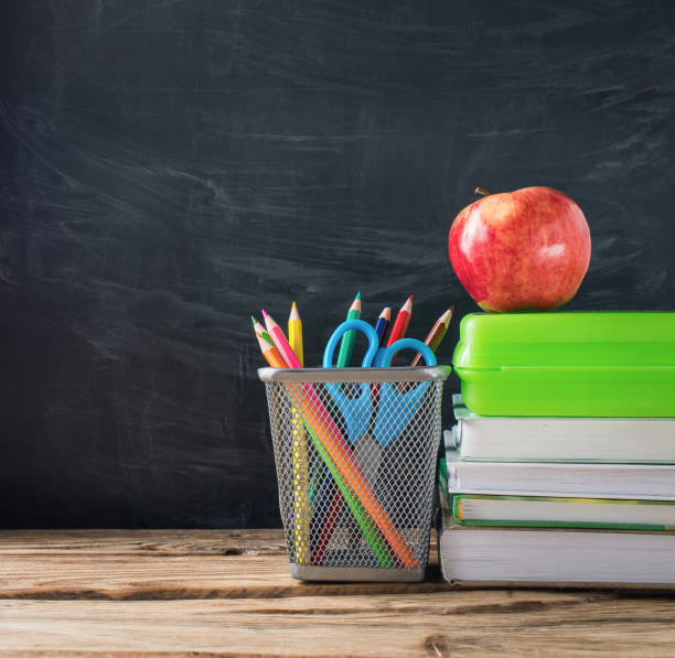 istock School books with stationery and apple on blackboard background 1033796332