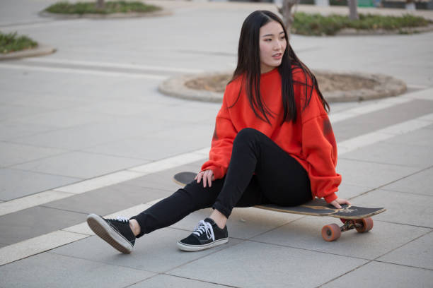 istock Young woman sitting on her skateboard 1033817434