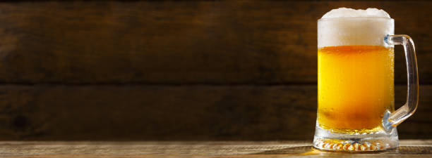 istock mug of beer on wooden table 1033820246
