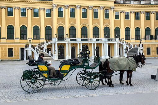 Horse drawn carriage in front of the Schonbrunn Palace. It was an imperial summer residence of the Habsburg monarchs. It is one of the most important cultural monuments in the country and a major tourist attractions in Vienna, Austria.