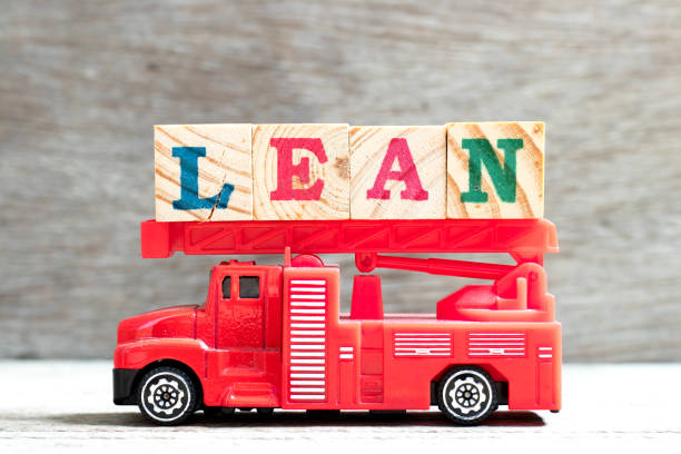 toy fire ladder truck hold letter block in word lean on wood background - manufaturing imagens e fotografias de stock