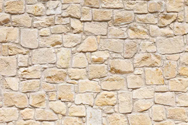 Wall of light, yellow Sandstone of different shapes and sizes. Background image, texture