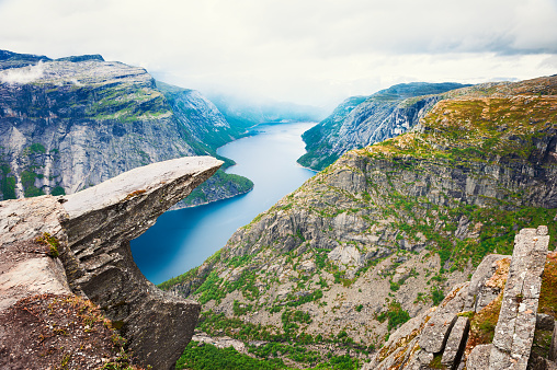 Trolltunga - famous landmark in Norway. Panoramic view of fjord lake and mountains, summer landscape