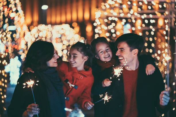 Happy family on Christmas with burning sparklers Young family with two kids celebrating New Year new year urban scene horizontal people stock pictures, royalty-free photos & images