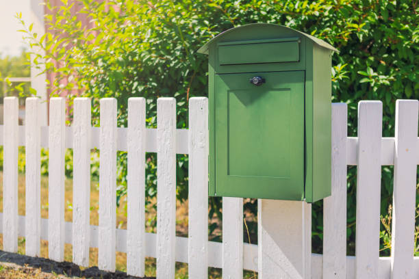 istock Green mailbox on a fence 1033834456