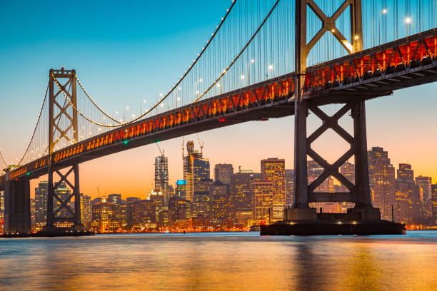 skyline de san francisco à oakland bay bridge au coucher du soleil, californie, é.-u. - beach architecture golden gate bridge night photos et images de collection