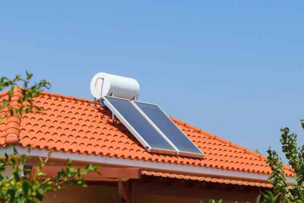 istock Solar water heating panel and water collector on a house roof. 1033839510