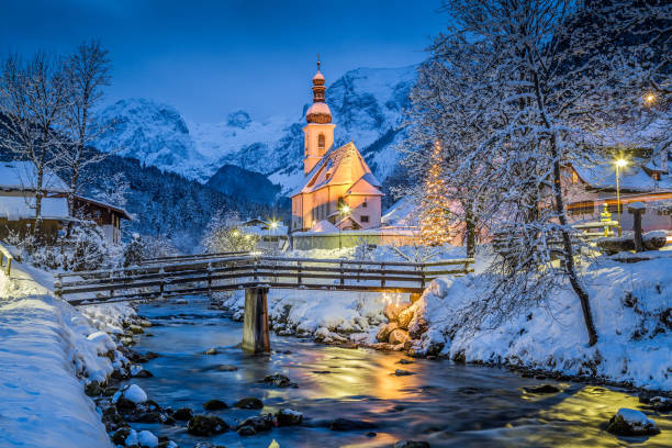 Church of Ramsau in winter twilight, Bavaria, Germany Beautiful twilight view of Sankt Sebastian pilgrimage church with decorated Christmas tree illuminated during blue hour at dusk in winter, Ramsau, Nationalpark Berchtesgadener Land, Bavaria, Germany european alps photos stock pictures, royalty-free photos & images