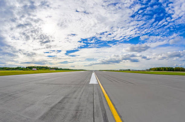 Airport runway to in horizon and picturesque clouds in the blue sky. Airport runway to in horizon and picturesque clouds in the blue sky airfield stock pictures, royalty-free photos & images